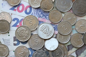 Ukraine money coins lying on mixed hryvnia banknotes. Finance background concept.