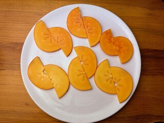 ripe persimmon fruits on a white isolated background persimmon fruits cut into slices