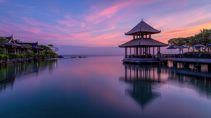 Fototapeta premium Serene sunset over calm water with pavilion.