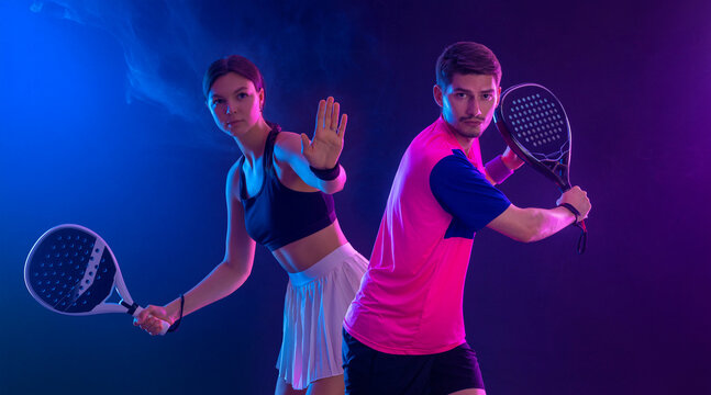 Two Padel tennis players with racket on open mix tournament. Woman and man athletes with paddle racket on court. Sport concept. Padel tour event.