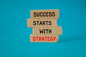 Success starts with strategy symbol. Concept words Success starts with strategy on brick blocks. Beautiful blue background. Business and success starts with strategy concept