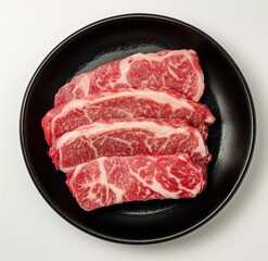 Top View of Marbled Beef Steak on Black Plate with Minimalist Background