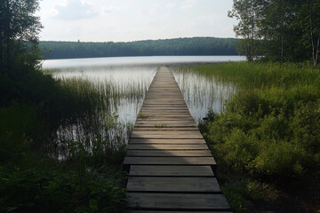 Obraz premium A plain wooden bridge stretching across a vast, calm lake.