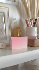 A minimalist desk setup featuring a gradient card, decorative items, and stationery.