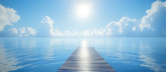 Scenic wooden pier extending into calm ocean waters under a bright blue sky with sunlight and...