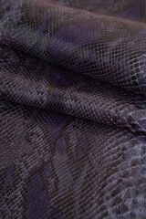 Obraz premium Snake skin fabric texture with waves and folds. Background with a reptile skin texture. Genuine python snakeskin