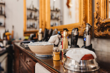 A barbershop with a bowl of shaving cream and a shaving brush on a counter