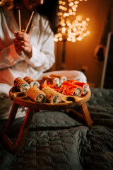 Savoring Delicious Sushi Rolls Under a Festive Christmas Tree for a Unique Holiday Culinary Experience