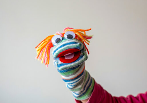 Colorful sock puppet performing in a playful indoor setting for children&rsquo;s entertainment