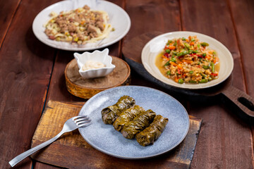 Couscous with vegetables, udon noodles with meat and homemade dolma on the table