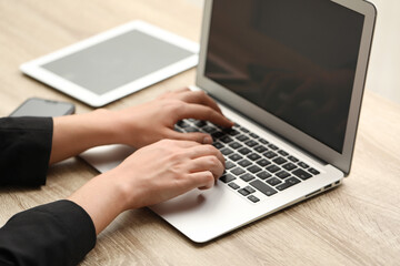 Businessman using laptop at wooden table, closeup. Modern technology