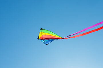 One colorful kite flying in blue sky
