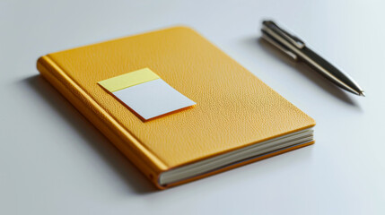 Yellow notebook with sticky notes and silver pen on white desk