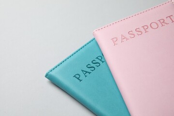 Passports in color covers on light background, closeup. Space for text