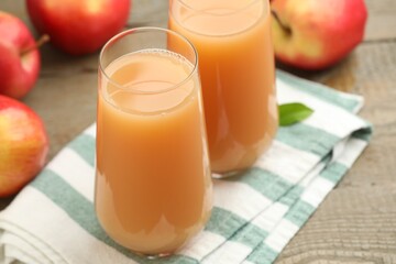 Tasty apple juice and fresh fruits on wooden table, closeup