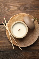 Soy candle and matches on wooden table, top view