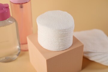 Clean cotton pads and micellar water on beige background