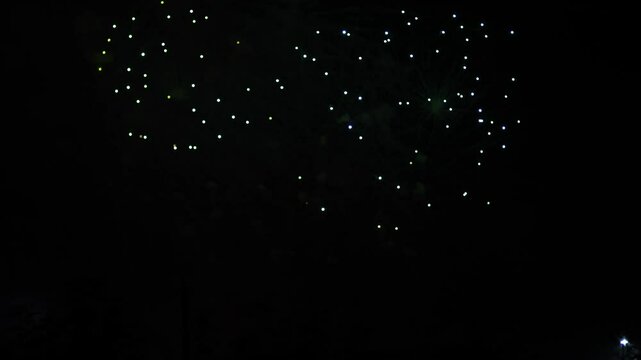 Silver red pink sparks scattering fireworks on the black night sky. General plan