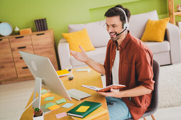 Young man in casual attire enjoying an online interaction at home workspace