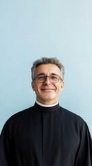 Fototapeta premium smiling catholic priest on blue background with copy space vertically 9:16