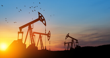 Oil drilling derricks at desert oilfield. The change in oil prices caused by the war. Oil price cap...