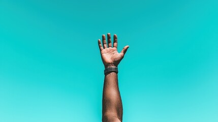 Hand reaching up towards a vibrant blue sky.