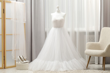 Fototapeta premium Beautiful wedding dress on mannequin and shoes in boutique