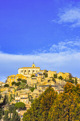 Obraz premium Front view, very, far distance of, the Village of Gordes, on French hilltop, in early evening sunlight