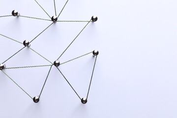 Network connection. Nails linked together by threads on white background, flat lay. Space for text