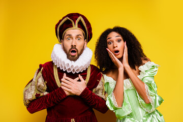 Dramatic Couple Dressed in Historical Costumes Expressing Surprise on a Vibrant Yellow Background