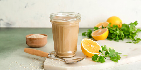 Jar of tasty tahini on light background