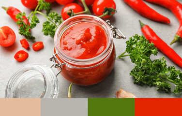 Jar of delicious tomato sauce on grey table