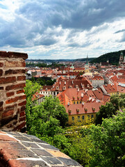 Fototapeta premium itle:Panoramic City View of Prague, Czech Repubic A stunning panoramic view of Prague, featuring the city’s iconic red rooftops, historic buildings, and the Vltava River. The image s