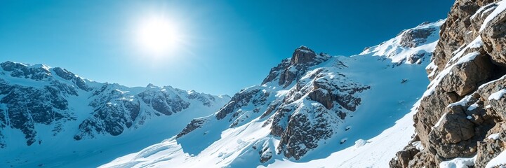Fototapeta premium Spring thaw in snowy mountain landscape, bright sun and clear blue sky, panoramic view