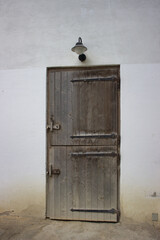 Rustic wooden door with metal hinges and lamp