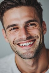 Fototapeta premium Close-up of a man smiling while brushing his teeth, with a toothbrush in his mouth