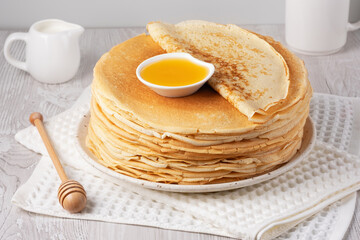 Stack of traditional russian pancakes blini on a white table. Homemade russian thin pancakes blini....