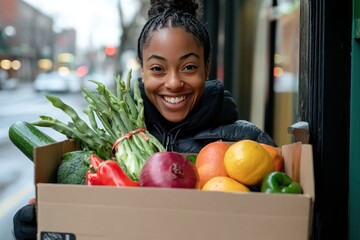Smiling woman holding a large box filled with fresh vegetables and fruits in an urban setting, showcasing healthy lifestyle and community engagement