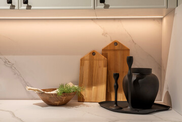 Stylish kitchen countertop features wooden cutting boards and ceramic utensils