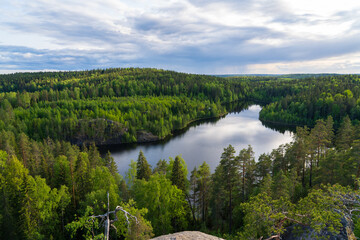 A forest lake among hills and rocks overgrown with coniferous forest.