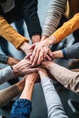 A group of people standing with their hands together, conveying unity and solidarity