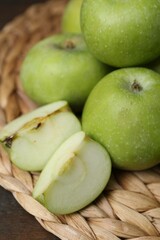 Whole and cut green apples on table, closeup