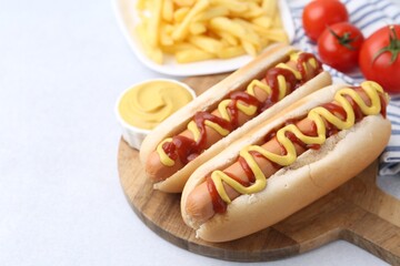Tasty hot dogs served on light table, closeup