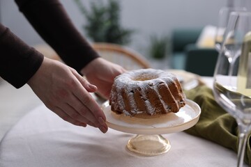Woman setting table for dinner at home, closeup
