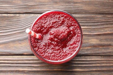 Fresh beetroot smoothie in glass on wooden table, top view