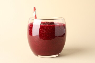 Fresh beetroot smoothie in glass on beige background, closeup