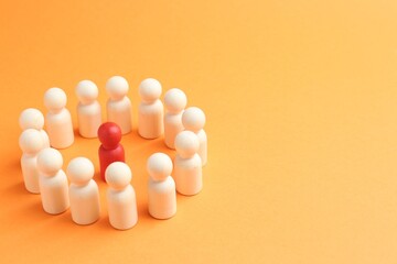Competition concept. Red human figure among white ones on orange background, closeup. Space for text