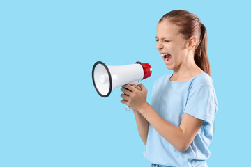 Teenage girl shouting into megaphone on blue background