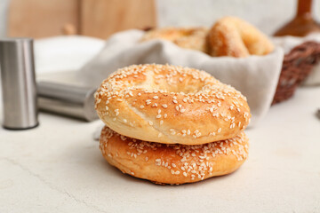 Tasty bagels with sesame seeds on white background