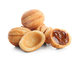 Many sweet walnut shaped cookies with boiled condensed milk on white background